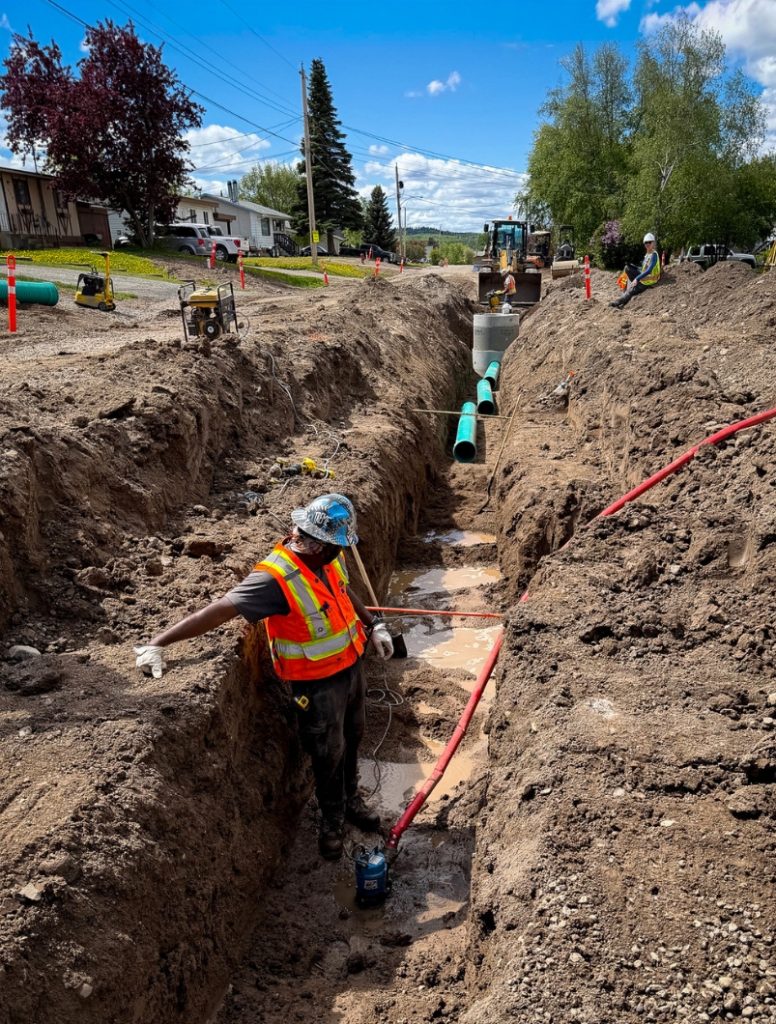 Dawson Civil crew installing storm main infrastructure within a trench excavation during municipal infrastructure upgrades in Fraser Lake, British Columbia.