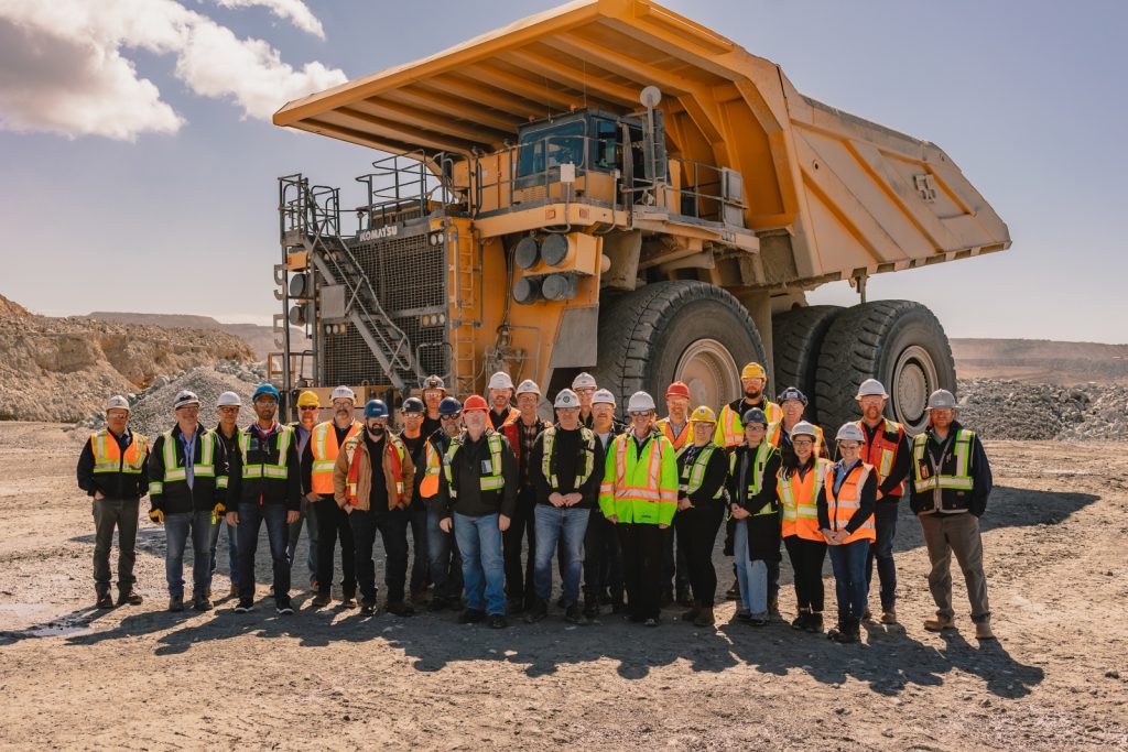Industry representatives standing in front of a large haul truck at Gibraltar Mine in British Columbia.